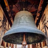 Wiszący u drewnianej powały ogromny dzwon 