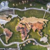 Zdjęcie dronowe przedstawia mapę świata z odwzorowanymi kontynentami Ziemi z oznaczonymi różnymi kolorami państwami.