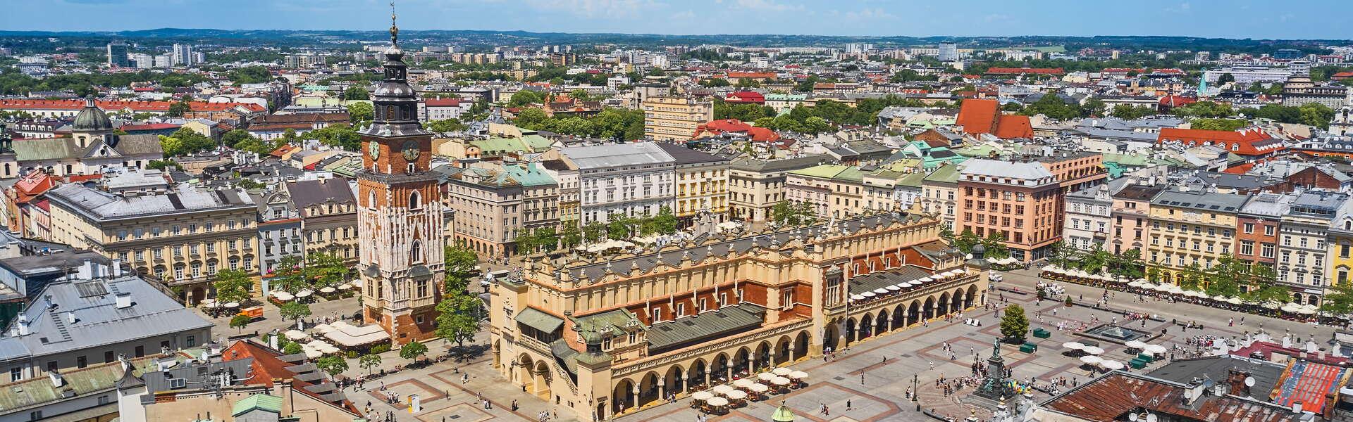 Kraków Stare Miasto z lotu Ptaka. Na pierwszym planie wieża Ratuszowa i Sukiennice. Po prawej w dole pomnik Adama Mickiewicza. W tle zabudowania miejskie.