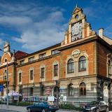 Duży budynek Starostwa Powiatowego w Bochni, częściowo otynkowany, częściowo z czerwonej cegły, stojący przy ulicy.